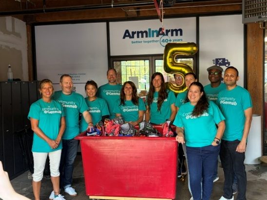 Volunteer team in teal shirts at an Arm In Arm event