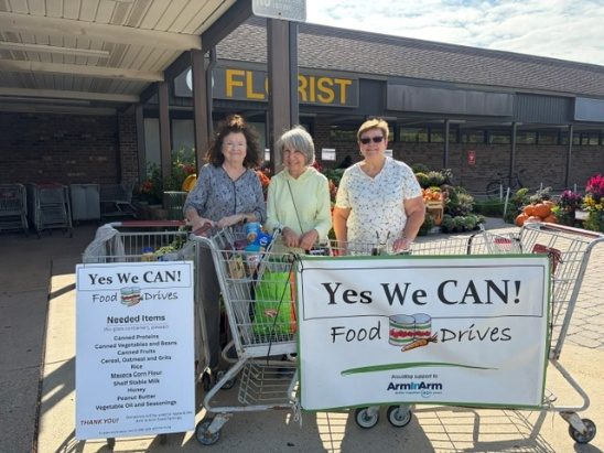 Yes We CAN! volunteers with shopping carts at a supermarket food drive